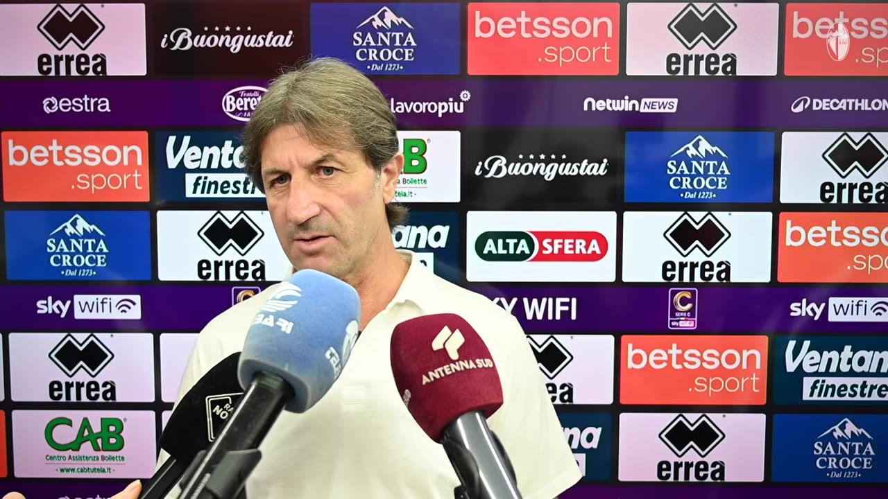 Allenatore che risponde davanti al backdrop