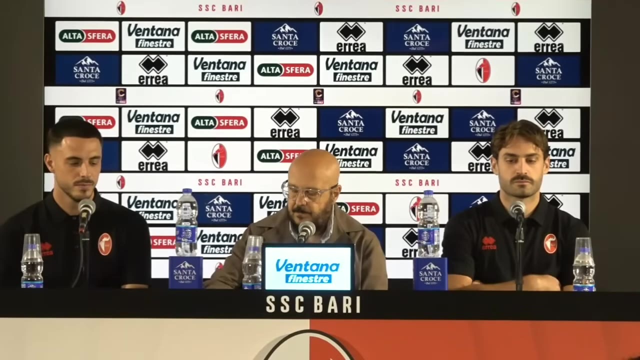 Tre uomini al tavolo della conferenza stampa