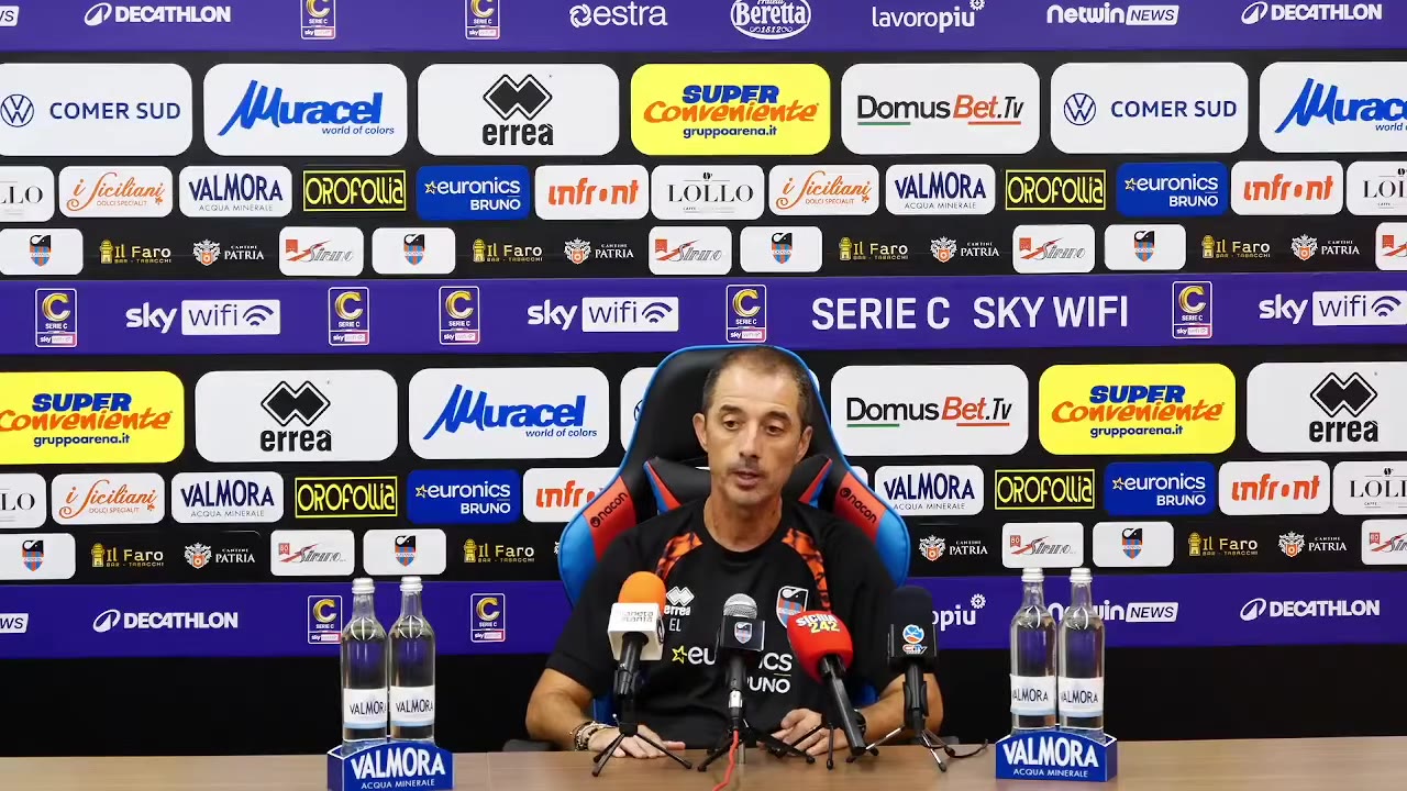 Allenatore parla ai microfoni in sala stampa
